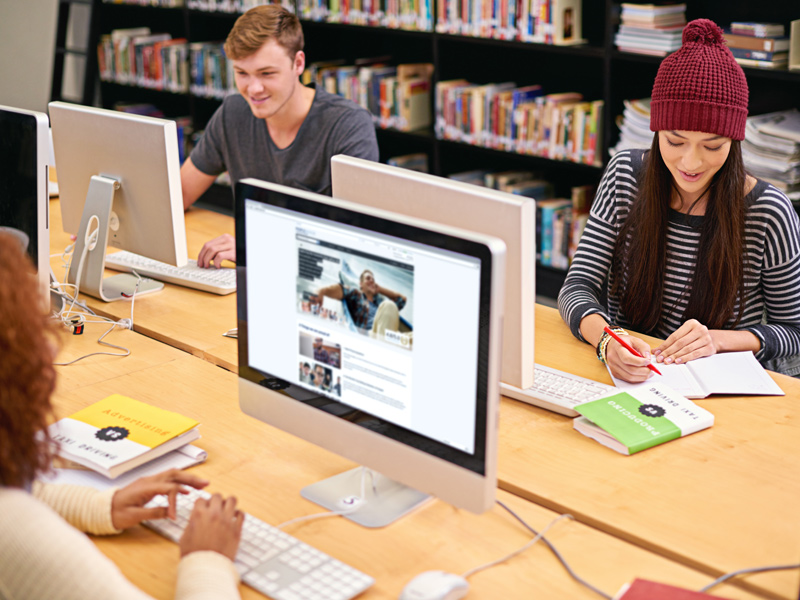 students on computers in academic library