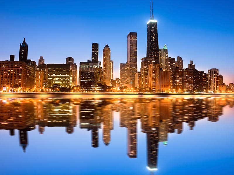 city skyline reflected in water at night