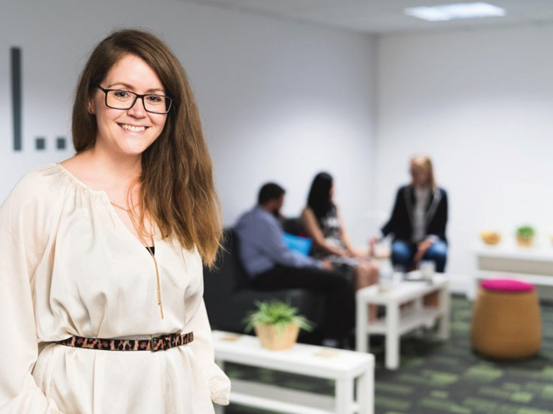 woman with glasses standing in front of group