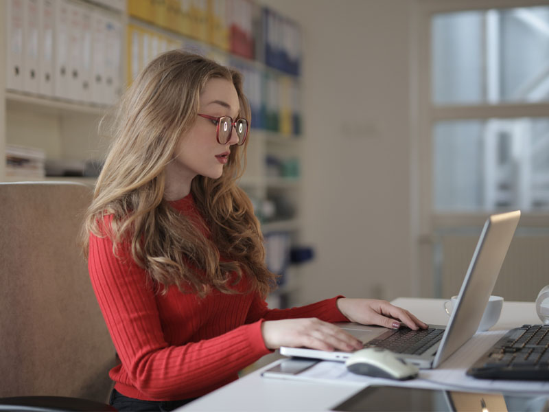 woman working on laptop in bright office