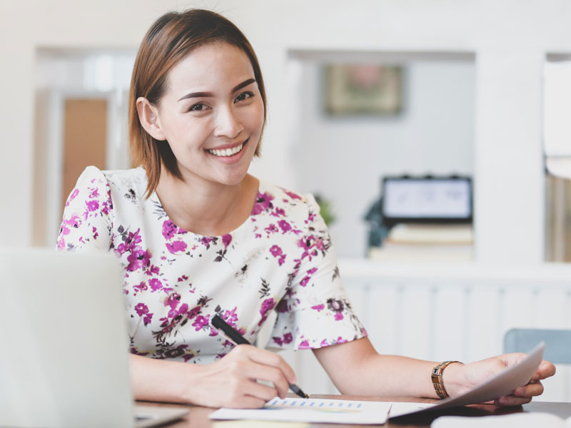 woman smiling while doing paperwork