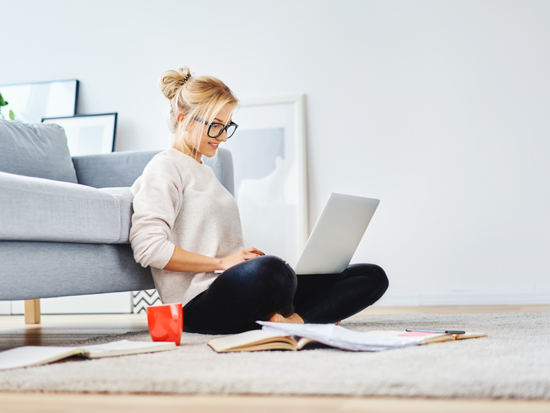 woman sitting on floor using laptop