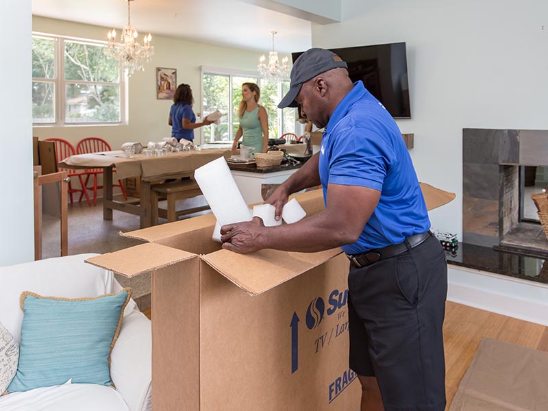home mover packing large tv in moving box