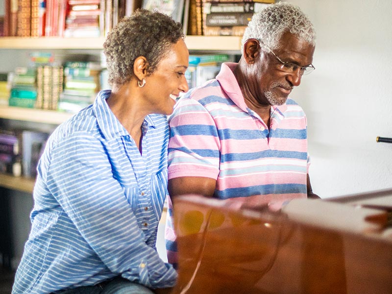 african american couple sitting at piano