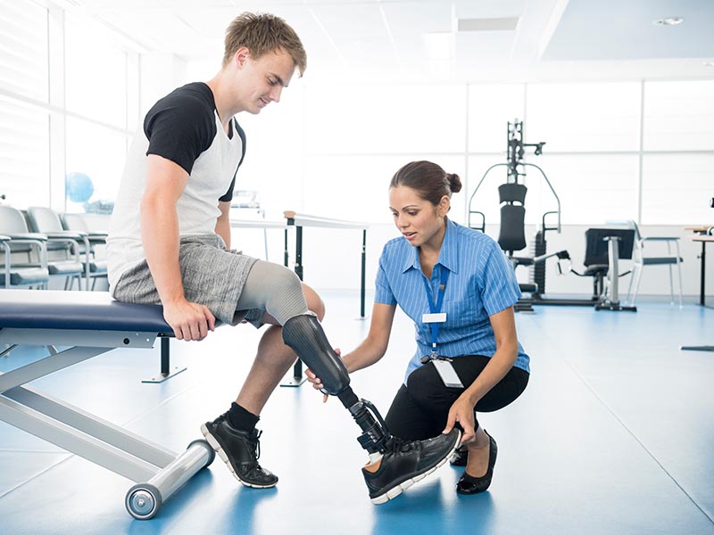 health professional helping man with prosthetic leg