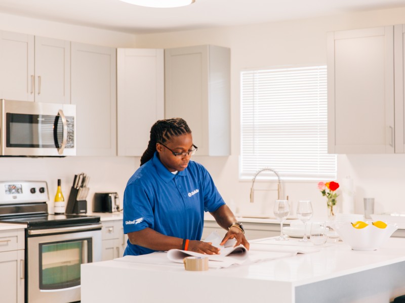 woman making move plans surrounded by moving boxes