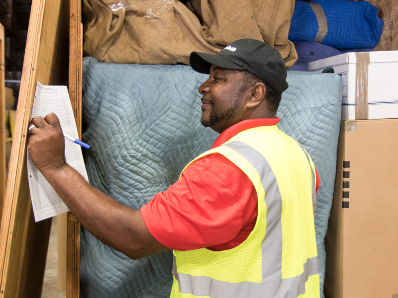 employee viewing paperwork of items in temperature controlled storage warehouse