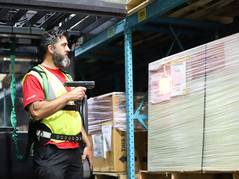 man scanning product on pallet in warehouse