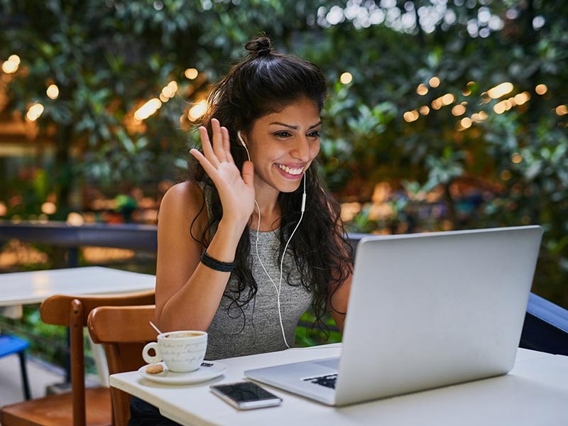 young female using webcam on laptop